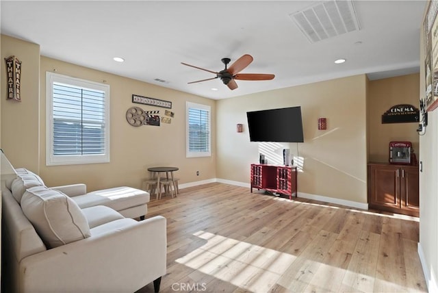 living room with ceiling fan and light wood-type flooring