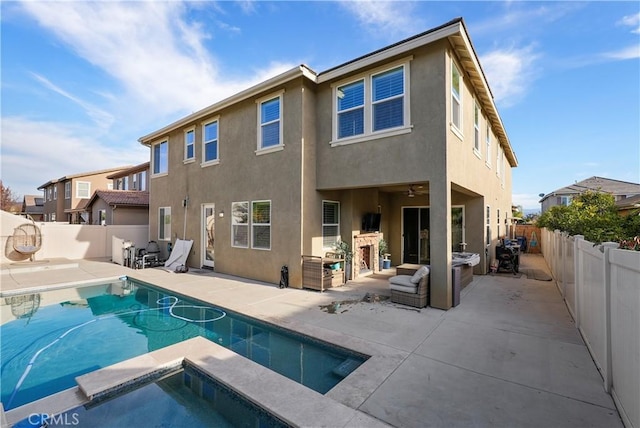 rear view of house with a pool with hot tub and a patio area