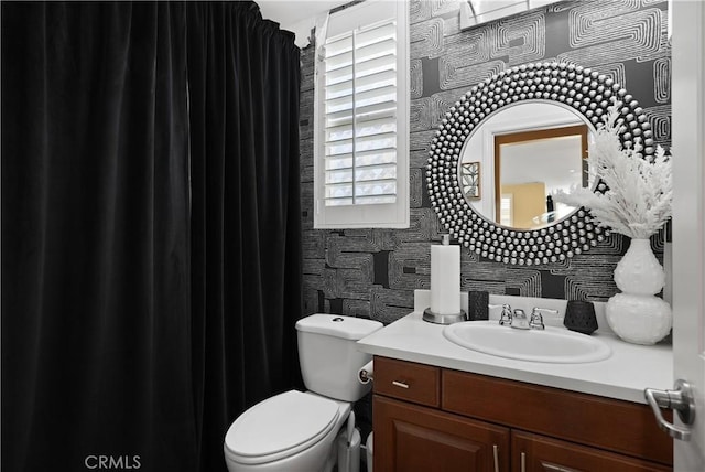 bathroom featuring a healthy amount of sunlight, vanity, and toilet