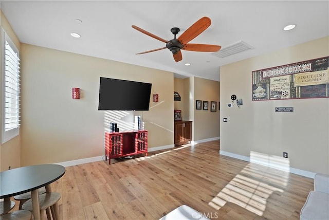 living room featuring ceiling fan and light hardwood / wood-style flooring