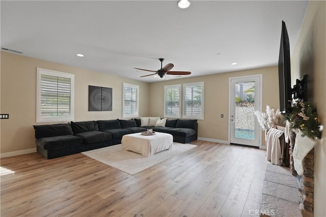 living room with light wood-type flooring and ceiling fan