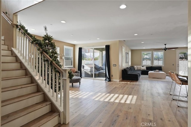 unfurnished living room featuring ceiling fan, light hardwood / wood-style flooring, and a wealth of natural light