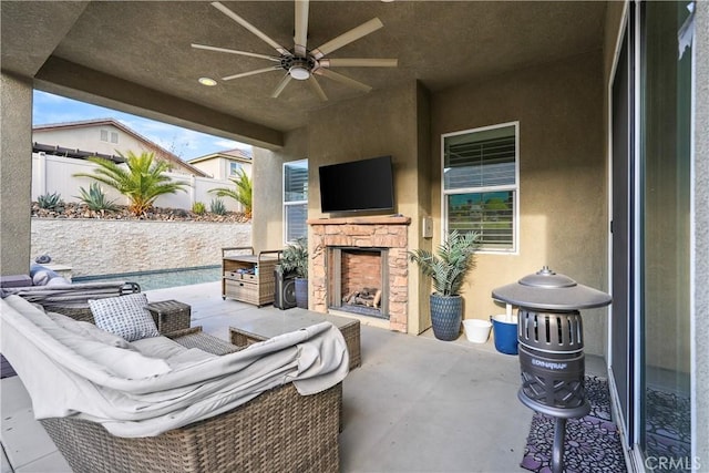 view of patio featuring ceiling fan and an outdoor stone fireplace