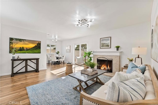 living room with light hardwood / wood-style floors and a notable chandelier