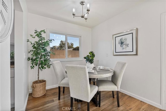 dining space with hardwood / wood-style flooring and an inviting chandelier