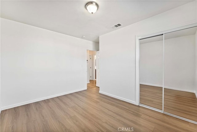 unfurnished bedroom featuring a closet and light hardwood / wood-style flooring