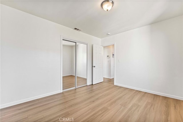 unfurnished bedroom featuring a closet and light wood-type flooring