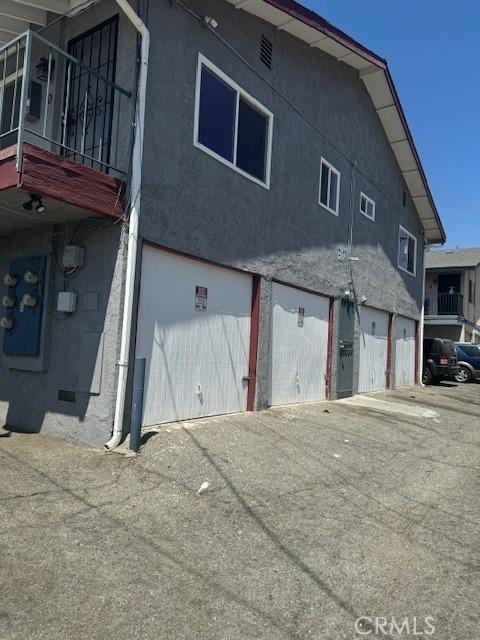 rear view of property with a balcony and a garage