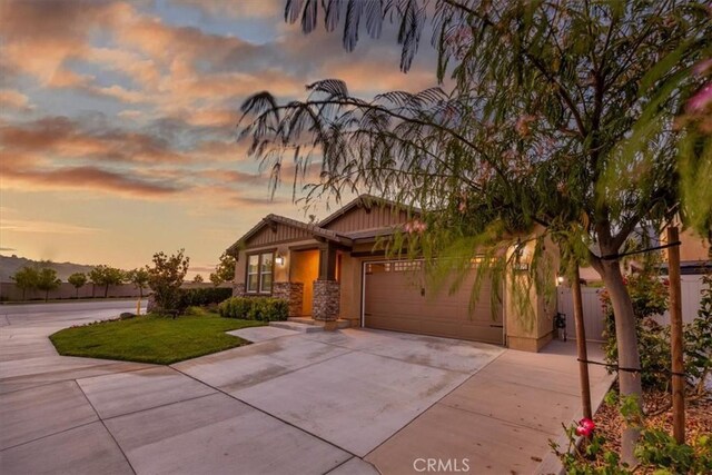 view of front of home with a garage and a lawn