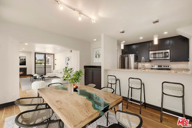 dining space featuring light wood-type flooring and sink