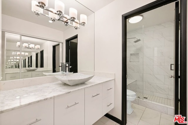 bathroom with toilet, vanity, and a shower with shower door