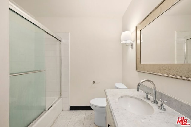 full bathroom featuring toilet, vanity, and enclosed tub / shower combo