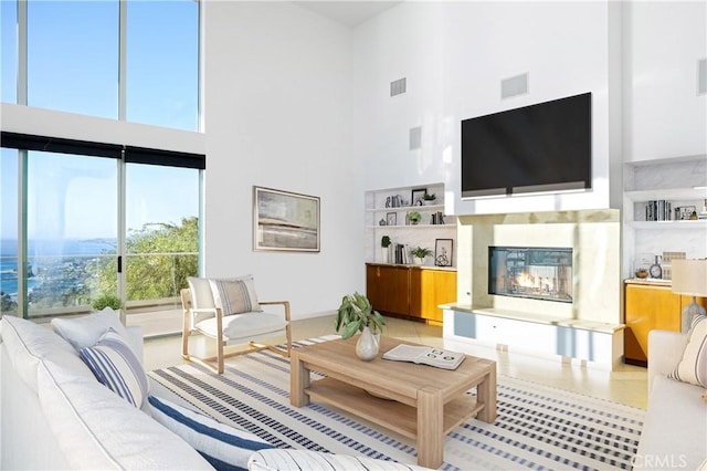 living room featuring a towering ceiling and built in shelves