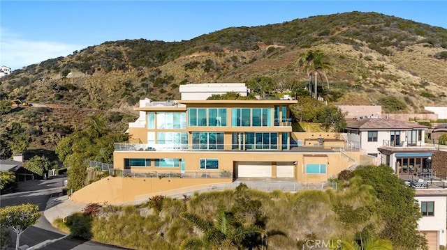 back of house with a garage and a mountain view