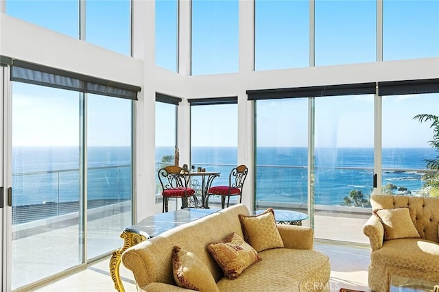 sunroom featuring a water view