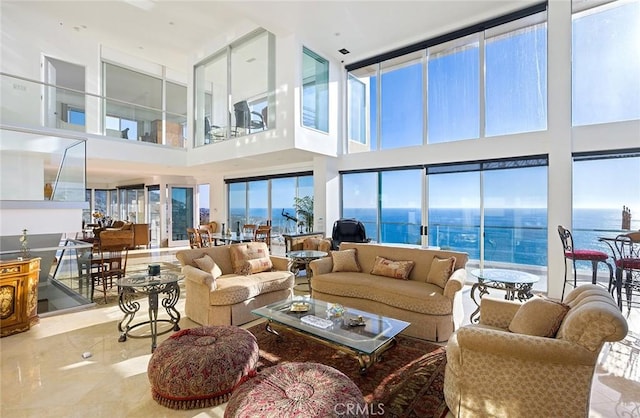 living room with a towering ceiling and a water view