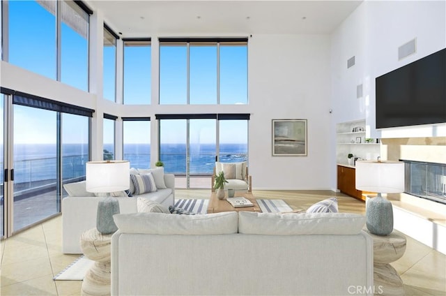 living room featuring a towering ceiling, light tile patterned floors, and a wealth of natural light