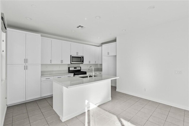 kitchen with a sink, visible vents, white cabinetry, light countertops, and appliances with stainless steel finishes