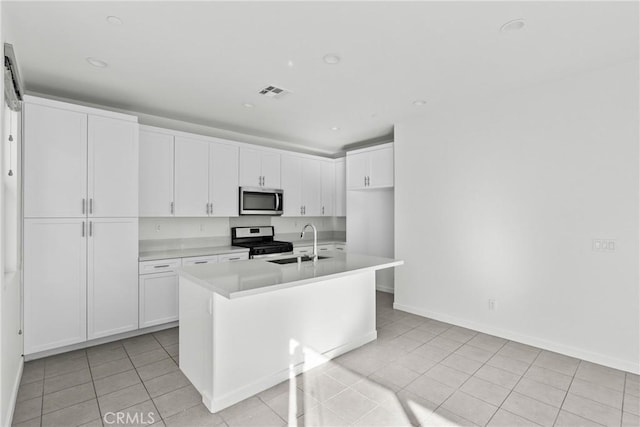 kitchen featuring visible vents, appliances with stainless steel finishes, a sink, light tile patterned floors, and light countertops