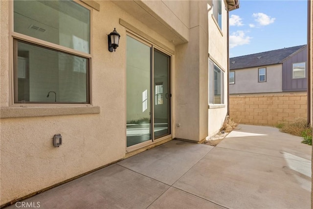 view of patio with visible vents and fence