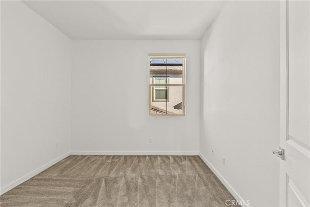 empty room featuring baseboards and carpet