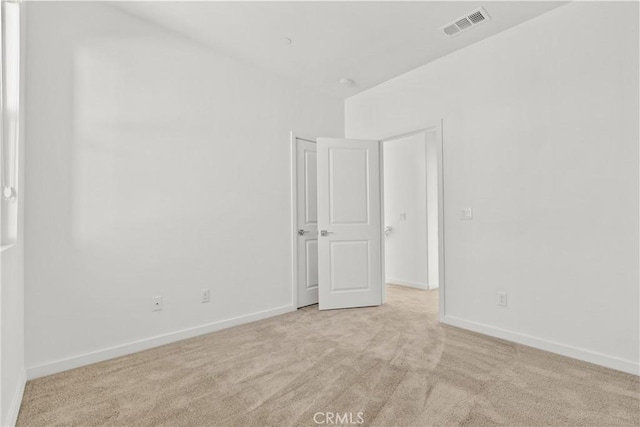 carpeted spare room featuring visible vents and baseboards