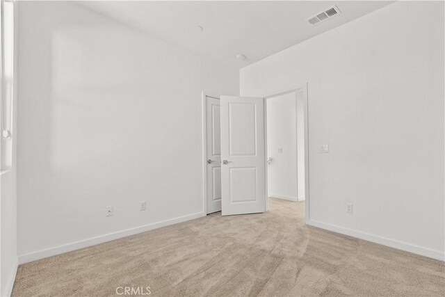 empty room featuring baseboards, carpet flooring, and visible vents