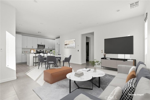 living room featuring visible vents, recessed lighting, light tile patterned flooring, and a healthy amount of sunlight
