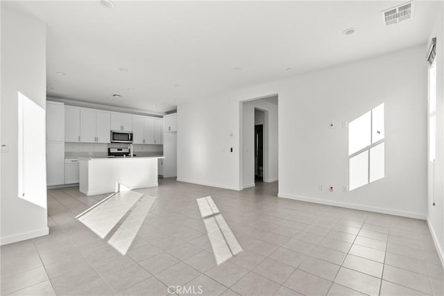 unfurnished living room with baseboards, recessed lighting, light tile patterned flooring, and visible vents