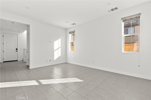 tiled spare room with baseboards and visible vents