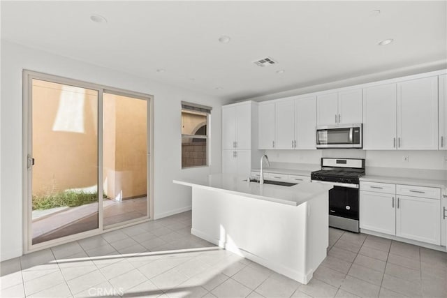 kitchen featuring visible vents, stainless steel appliances, a sink, and light countertops