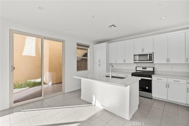 kitchen featuring light countertops, appliances with stainless steel finishes, a sink, and visible vents