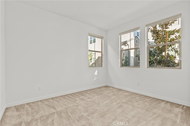 carpeted empty room featuring baseboards