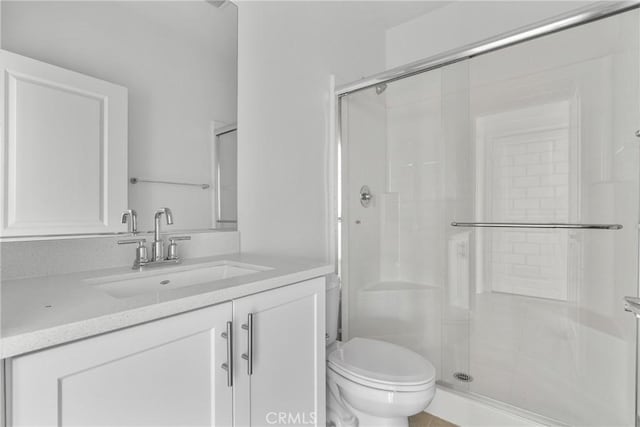 bathroom with toilet, a shower stall, and vanity