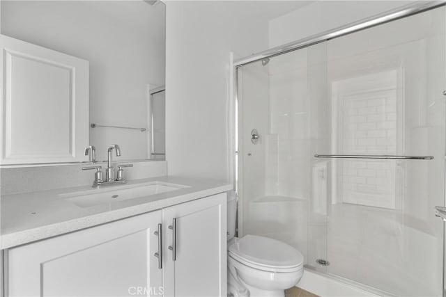 full bathroom featuring vanity, a shower stall, and toilet