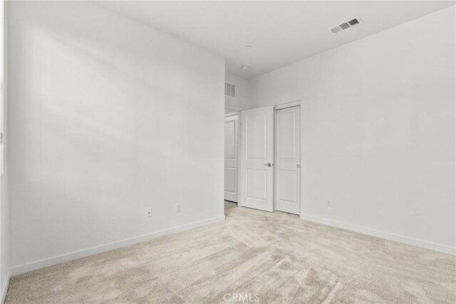 unfurnished bedroom featuring baseboards, visible vents, and carpet
