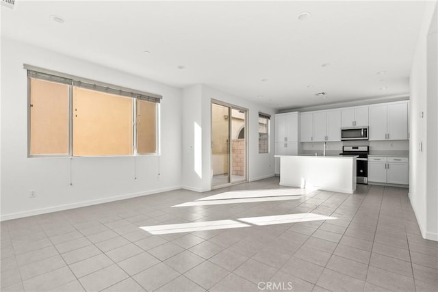 unfurnished living room featuring baseboards, recessed lighting, and light tile patterned floors