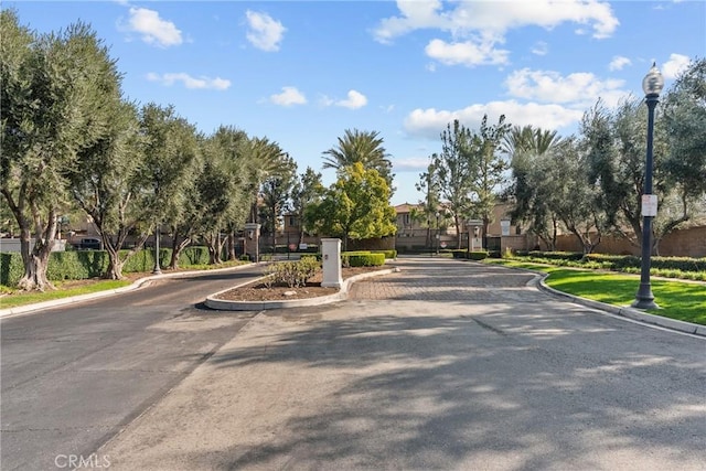 15992 Jamie Ln Unit 1, Fontana, CA 92336 - view of asphalt road with curbs, street lights, a gated entry, and a residential view