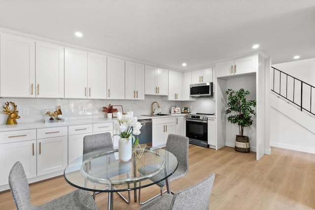 kitchen featuring light hardwood / wood-style floors, sink, white cabinetry, and appliances with stainless steel finishes