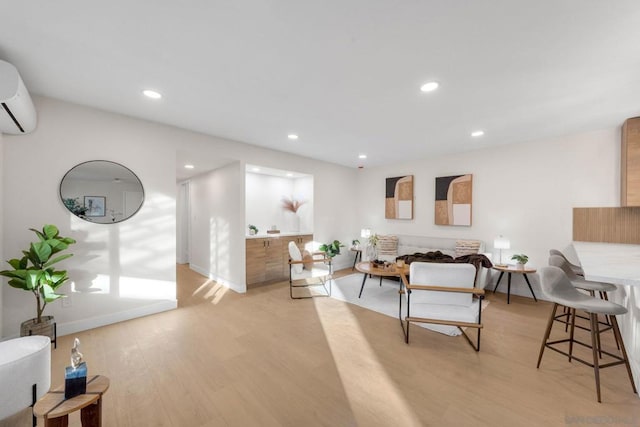 living room featuring light hardwood / wood-style floors and a wall unit AC