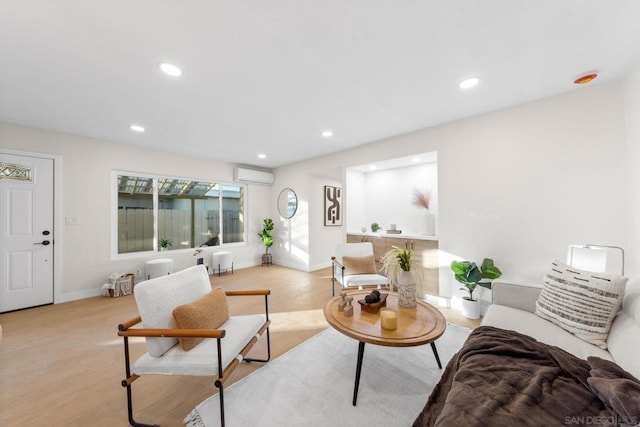 living room featuring light wood-type flooring and a wall mounted air conditioner