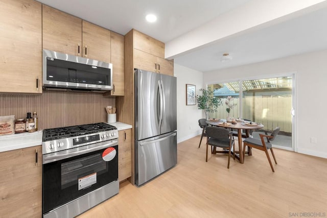 kitchen featuring light brown cabinets, decorative backsplash, light hardwood / wood-style floors, and appliances with stainless steel finishes