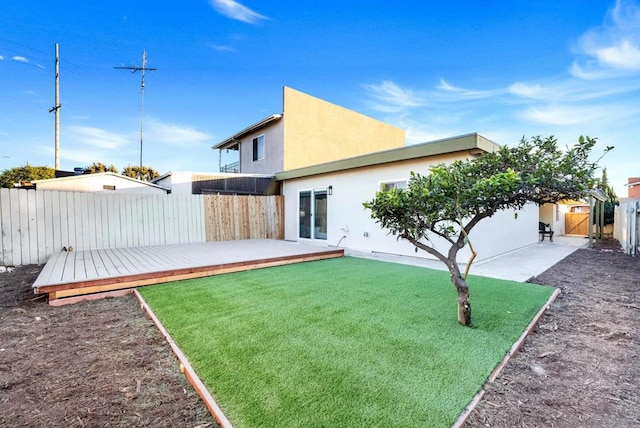 rear view of house featuring a patio, a deck, and a yard