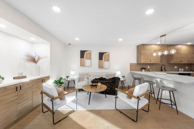 living room featuring sink and light hardwood / wood-style floors