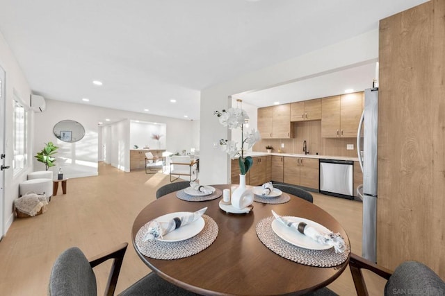 dining area featuring an AC wall unit and light hardwood / wood-style floors