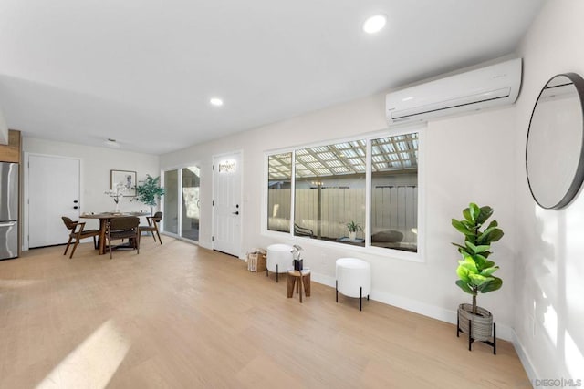 interior space with a wall unit AC and light wood-type flooring