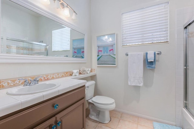 full bathroom featuring toilet, bath / shower combo with glass door, tile patterned floors, and vanity