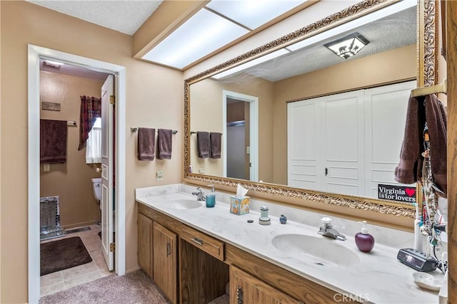 bathroom featuring toilet, vanity, and tile patterned flooring