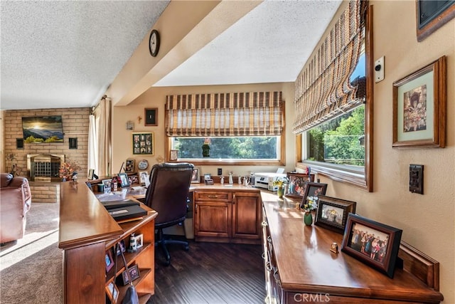 home office with a brick fireplace, a textured ceiling, and dark hardwood / wood-style floors