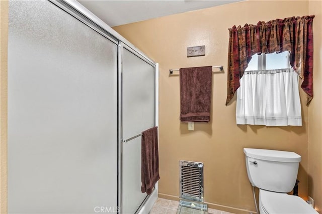 bathroom featuring tile patterned floors, toilet, and an enclosed shower